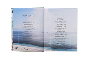 An open book shows a table of contents with chapter titles and page numbers over a beach and ocean backdrop, capturing the tropical vibe of Vendome’s Island Dreaming collection.