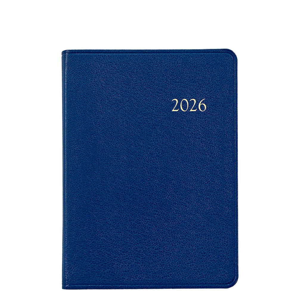 The Graphic Image 2026 Weekly Journal Planner Collection features a blue leather notebook with "2026" embossed in gold, shown on a white background—ideal for scheduling with dedicated appointment pages.