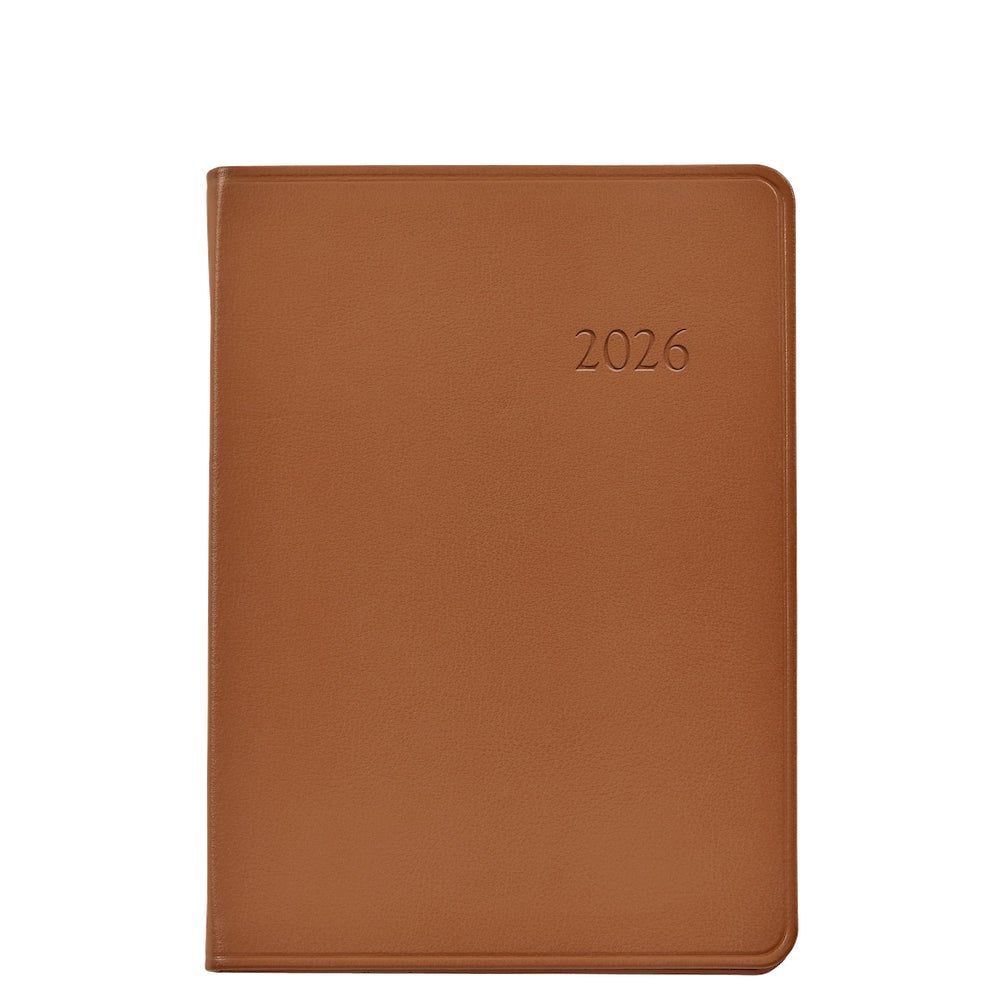 The Graphic Image 2026 Weekly Journal Planner Collection features a brown leather notebook with "2026" embossed on the cover, shown closed against a white background.