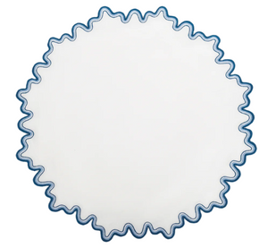 The Matouk Wave Tabletop Collection, Aquarius, features a round white plate with a blue wavy edge—ideal for pairing with linen napkins or an embroidered tablecloth for an elegant dining touch.