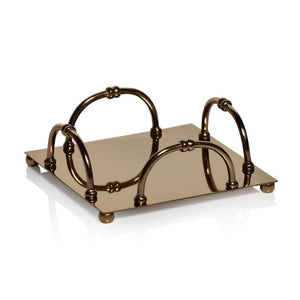 The Zodax Alessia Gold Napkin Holder features a square design with four arched handles, ball feet, and a polished gold finish, reflecting elegantly on a white surface.