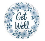 The Signature Balloon by Burton+Burton features a round design adorned with a floral wreath and the words "Get Well" in the center. The flowers and text come in varying shades of blue, perfectly complementing our exquisite floral arrangements available for local delivery.