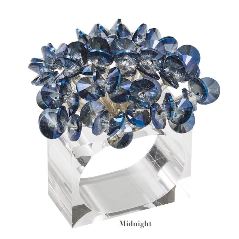 The Aster Napkin Ring by Kim Seybert features a clear rectangular band adorned with clustered, faceted blue beads—an eye-catching table accent reminiscent of shimmering glass jewels.