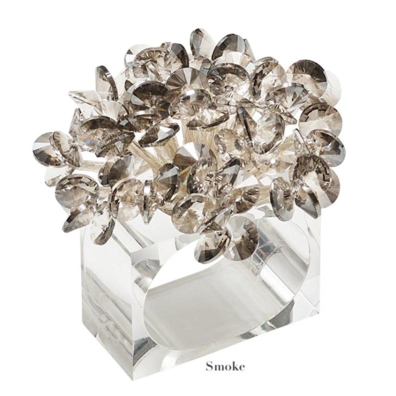 The Kim Seybert Aster Napkin Ring features a clear rectangular design topped with clustered, smoky faceted crystals. The word "Smoke" appears below, making it a perfect elegant accent for dining table décor.