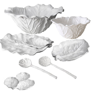 The Beatriz Ball Vida Lettuce Serveware Collection features white ceramic bowls, plates, and spoons shaped like leaves, elegantly displayed on a white background.