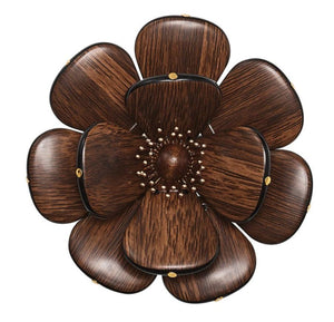 The Begonia Napkin Ring by Kim Seybert features a wooden flower with eight rounded petals, a textured center, and golden accents, adding natural beauty to any table setting.