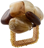 The Kim Seybert Sea Stone Napkin Ring features a square design, beaded gold-tone band, and polished brown and beige beach stones clustered on top—an elegant accent for your table setting.