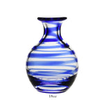 The Bella Blue Carafe Collection by William Yeoward Crystal features an 18 oz round, clear glass vase with blue and white swirls—ideal for flowers or wine. Complies with carafe standards; includes a Proposition 65 warning.