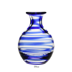 The Bella Blue Carafe Collection by William Yeoward Crystal features an 18 oz round, clear glass vase with blue and white swirls—ideal for flowers or wine. Complies with carafe standards; includes a Proposition 65 warning.