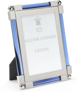 The Light Blue Classic Frame Collection by William Yeoward Crystal features a rectangular, nickel-plated photo frame with silver metal edges and blue glass accents; this classic item may carry a Proposition 65 warning.