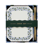 The Blue Hydrangea Desk Accessory Collection by Riffle Paper Co. includes a floral-bordered notepad and gold pen, making it the perfect addition to any workspace.