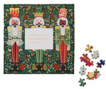 A box of Riffle Paper Co.'s Nutcracker Brigade Puzzle, showing three illustrated nutcrackers on the cover, with several loose puzzle pieces beside it.