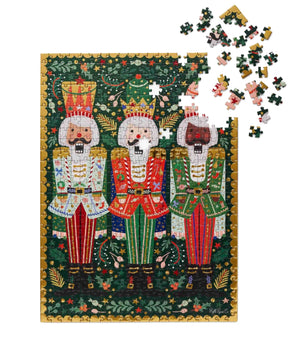 This partially assembled Rifle Paper Co. Nutcracker Brigade Puzzle showcases the colorful uniforms of the Nutcracker Brigade against a green and gold backdrop, with some pieces scattered above to highlight its whimsical design by Riffle Paper Co.