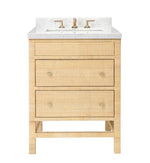 The Isla Vanity Collection by Made Goods features light wood rattan, three drawers, a white countertop with integrated sink, and brass faucet fixtures to add organic warmth to your bathroom.