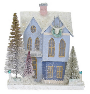 The Cody Foster Purple Frosted Mansionette features gold-trimmed windows, a snowy roof, wreath, chimney, and sits among four snow-dusted bottlebrush trees on a white base—a charming piece of home decor.