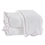 A stack of three Matouk Cairo Scallop Bath Collection towels, made from long-staple cotton with light piping along the edges, is neatly arranged against a plain background.