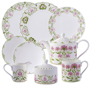 The Royal Crown Derby Cobblers Cove Camelot Dinnerware Collection features white fine bone china dishes, teapots, cups, and a creamer adorned with elegant green and pink floral patterns.