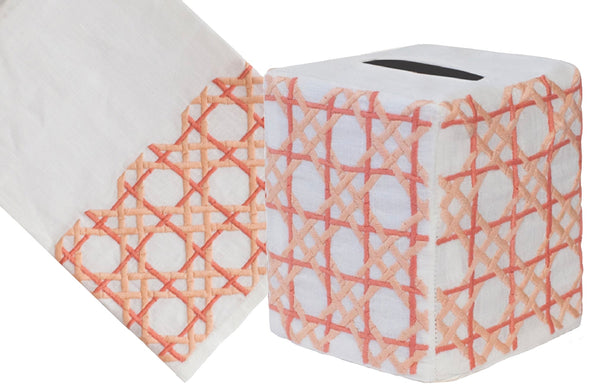 A roll of Cane Collection, Coral toilet paper with a geometric red and white pattern, alongside a partially unfolded sheet showing the same design, crafted from Italian linen by Haute Home.