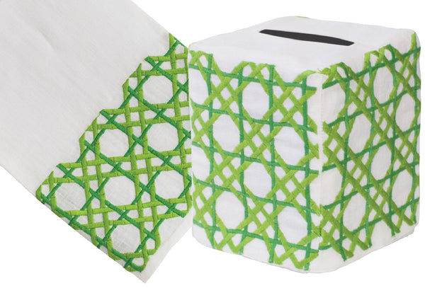 A white hand embroidered Cane Collection, Green tip towel roll with a green lattice pattern design next to a folded tip towel displaying the same pattern on Italian linen by Haute Home.