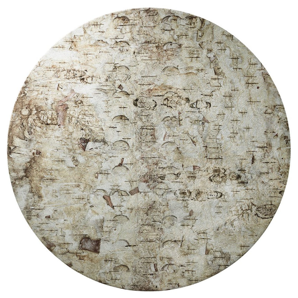The Kim Seybert Chalet Placemat features a round, flat surface with a worn, textured pattern in beige and brown, resembling weathered stone—ideal for nature-inspired table decor.