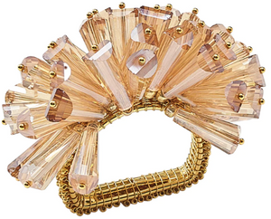 The Kim Seybert Dazzle Napkin Ring features multiple fan-shaped, faceted peach glass beads on a gold rectangular base, creating an elegant and sparkling accessory for your table setting.