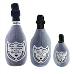 The Haute Diggity Dog "Dog Perignonn Champagne Dog Toy Collection" features three plush, squeaky toys in small, medium, and large sizes. Each is shaped like a champagne bottle with heart and bone designs for playful pups.