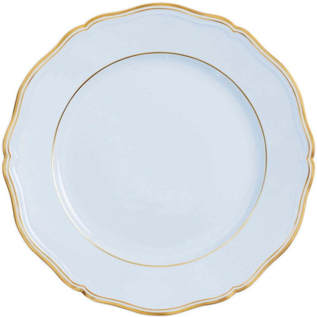 A white porcelain plate from the Raynaud Mazurka Or Fond Bleu Gris Dinnerware Collection, featuring a scalloped edge and a gold rim.