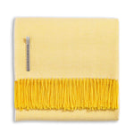 Alicia Adams Alpaca Classic Herringbone Throw: a folded yellow baby alpaca blanket with darker yellow fringe, fair-trade made in Peru, features a herringbone pattern and side fabric tag.
