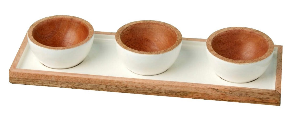 The Be Home Madras Classic Dipping Bowl Set features three small handcrafted mango wood bowls with white exteriors, elegantly arranged on a rectangular wooden tray for a sustainably sourced presentation.