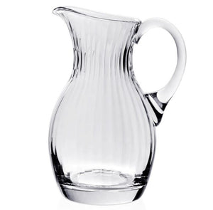 The Corinne Pitcher by William Yeoward Crystal is crafted from handmade crystal glass with a curved handle and vertical ribbed design, part of the elegant Corinne Collection. Shown on a white background.