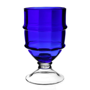 The Cotswold Footed Hurricane Collection by William Yeoward Crystal features a blue glass goblet with a clear stem and round base, inspired by traditional glassblowing, shown against a white background.