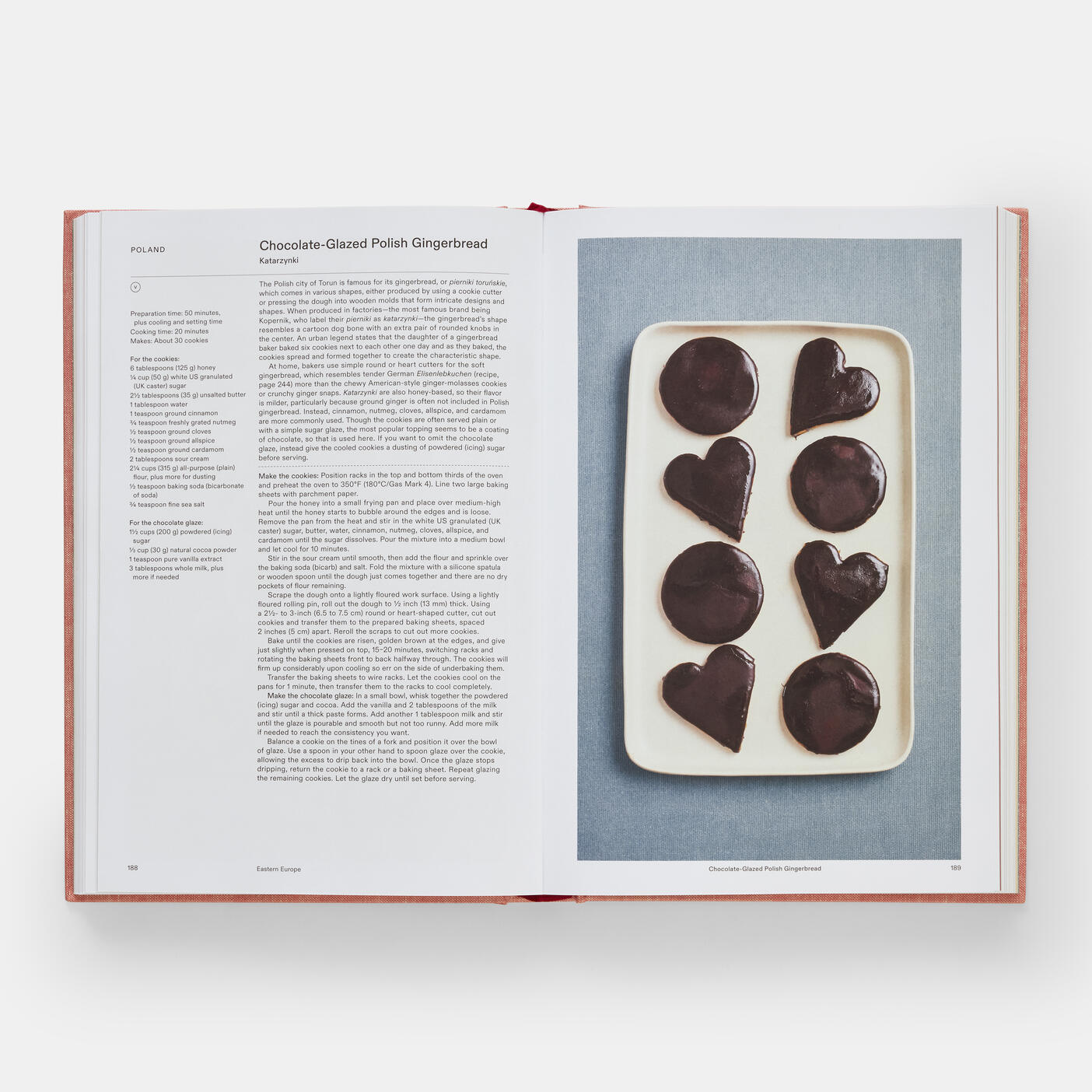 An open copy of "Crumbs: Cookies and Sweets from Around the World" by Phaidon reveals a tempting chocolate-glazed Polish gingerbread recipe on the left and heart-shaped cookies on the right, ideal for international recipe enthusiasts.