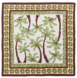 The Oasis Napkin Set by Kim Seybert is made from 100% linen, featuring green and brown leaf borders with palm tree designs on a white background for a fresh, tropical look.