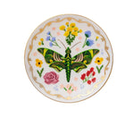 The Curio Desk Accessory Collection round porcelain plate by Rifle Paper Co. showcases a central green moth, illustrated bugs, bright florals, and a gold-trimmed edge—ideal for garden lovers.