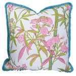 The Enchanted Garden Bamboo Outdoor Pillow by Associated Design is a 22"x22" square decorative pillow with a white base, pink and green floral pattern, blue fringe trim, and premium Custom-Poly Fill. Handmade in the USA for lasting comfort and style.