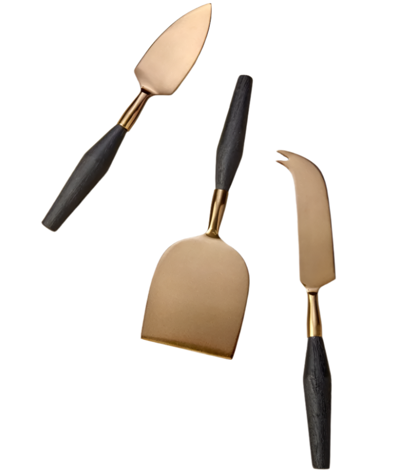 The Arendal Cheese Knife Set by Be Home features three gold-toned, black-handled knives arranged on a white background, highlighting their stylish and ethically crafted design.