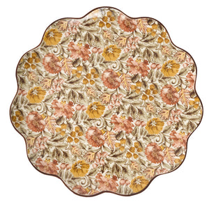 The Willa Dinnerware Collection by Juliska features a round, scalloped-edged serving platter adorned with romantic floral and leaf patterns in warm browns, oranges, golds, and beige on a cream background.