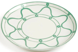 A white ceramic plate from the Themis Z Serenity Green Dinnerware Collection features green wavy and circular patterns around the rim and inner border, reflecting the collection's organic-inspired hues.
