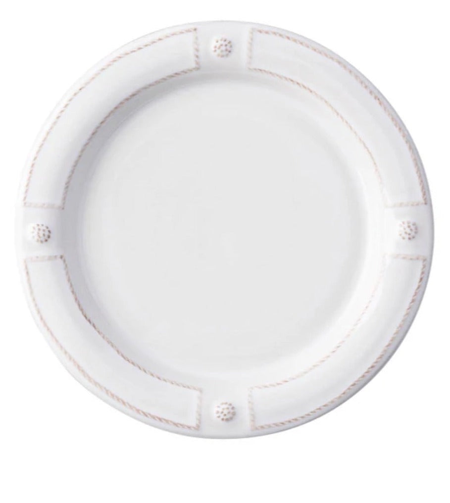A round white ceramic plate from Juliska’s Berry & Thread French Panel Dinnerware Collection, featuring a raised rim inspired by Parisian architecture with four textured accents evenly spaced around the edge.