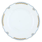 Herend’s Princess Victoria Light Blue Collection features a white porcelain plate with scalloped edges, gold trim, and delicate blue accents, echoing timeless elegance fit for royalty.
