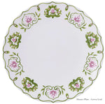 The Royal Crown Derby Cobblers Cove Camelot Dinnerware Collection offers a round white bone china dinner plate with a green and pink floral rim—ideal for luxury boutique hotel settings.