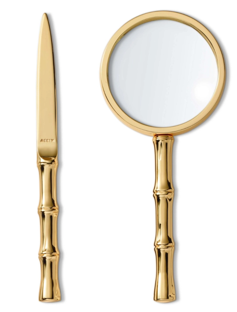 The Ava Bamboo Magnifying Glass and Letter Opener by Aerin, featuring bamboo-inspired handles and a gold finish, are displayed on a white background.