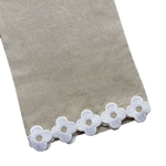 Dolly Tip Towel, Flax 100% linen fabric with a decorative border of white lace flowers, displayed on a black background by Haute Home.