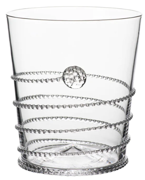 A clear glass tumbler from the Juliska Amalia Drinkware Collection features a textured spiral wrapping the exterior and a raised circular accent, showcasing intricate details crafted by master glass artists.