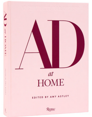 AD at Home: Architectural Digest" is a pink hardcover book by Rizzoli, celebrating creative homes and expert interior design.