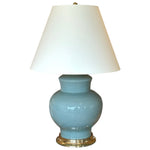 The Kim Lamp in Duck Egg by Christopher Spitzmiller features a glossy blue ceramic base, gold accent, and white tapered shade—an ideal touch for cozy corners.