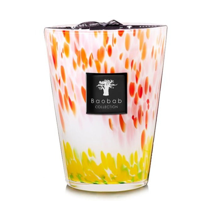 A decorative Baobab Collection Eden Garden Candle baobab candle in a multicolored glass holder with red, yellow, and white patterns.