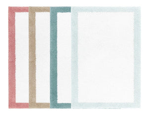 Four Egoist Border Bath Rugs by Graciozza—rectangular, made of luxurious Egyptian cotton with pink, beige, teal, and light blue borders—are arranged overlapping on a white background.