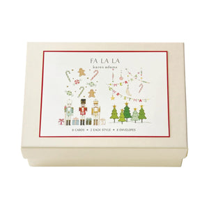 The Karen Adams Note Card Box Set comes in a cream-colored box with a festive Christmas label featuring ornaments, presents, nutcracker, and trees. Includes 8 natural white note cards and envelopes. “FA LA LA”—a perfect hostess gift!.