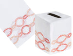 The Haute Home Foam Bath Collection features a coral tissue box cover, skillfully crafted from Italian linen with hand-embroidered red and orange intertwined loops.